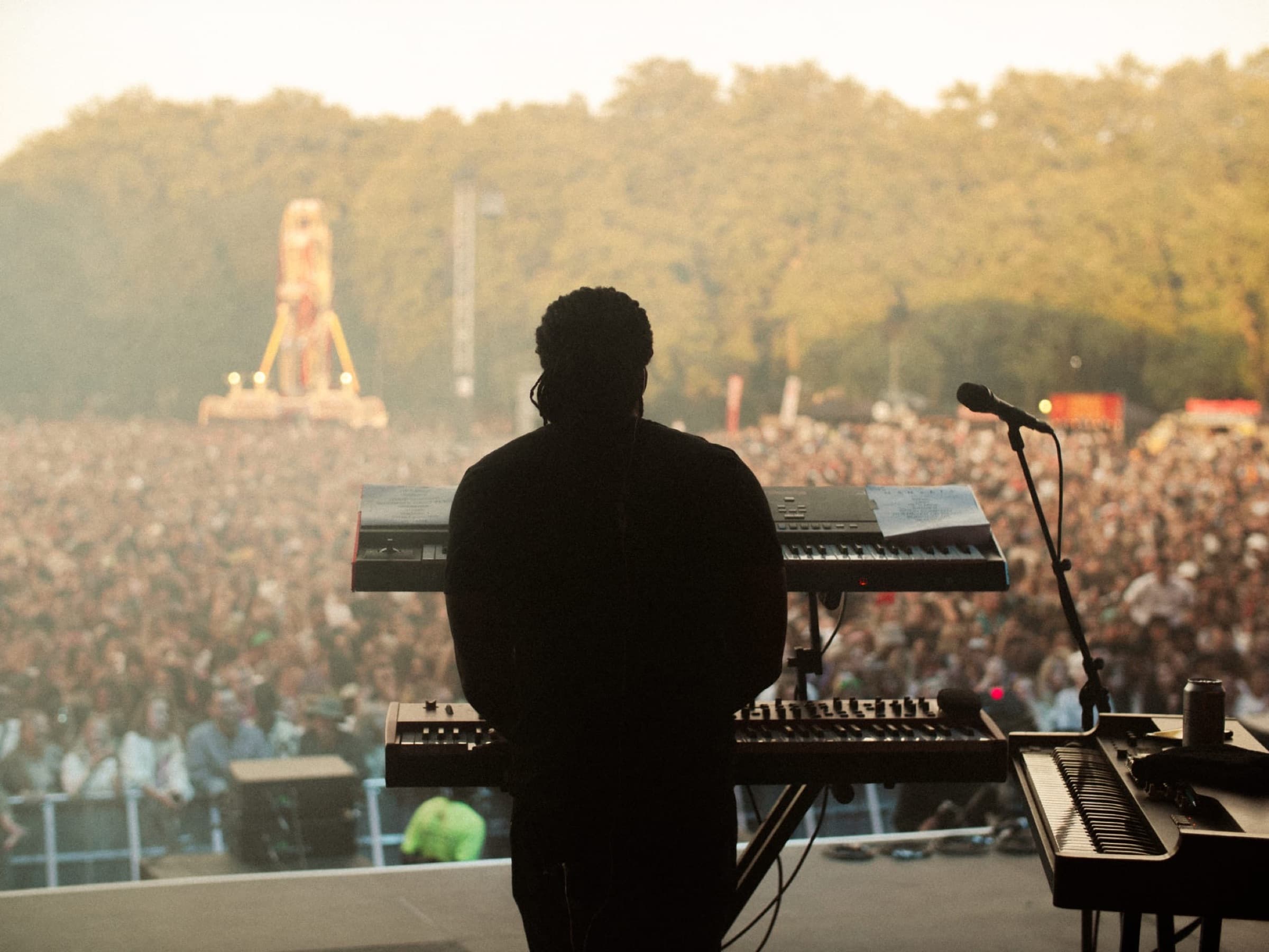 Dan performing to a festival crowd at sunset
